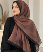 Châle hijab tie & dye brun à bordure noire, porté avec une tenue noire.