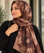 Châle hijab à grandes fleurs brunes et rose poudré porté avec une tenue noire.