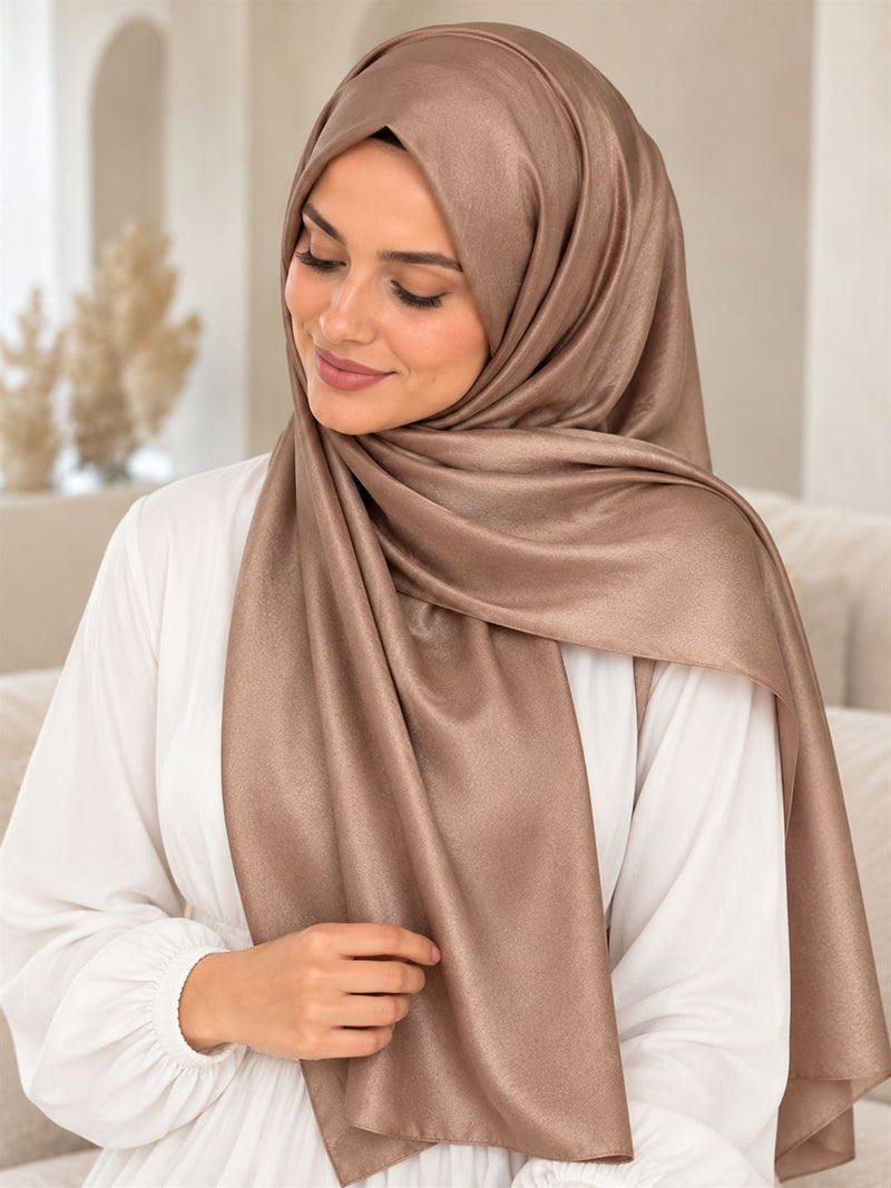 Châle satiné cappuccino porté en drapé sur l’épaule avec une tenue blanche