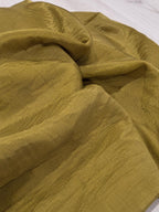 Détail de la texture et des reflets du châle vert olive