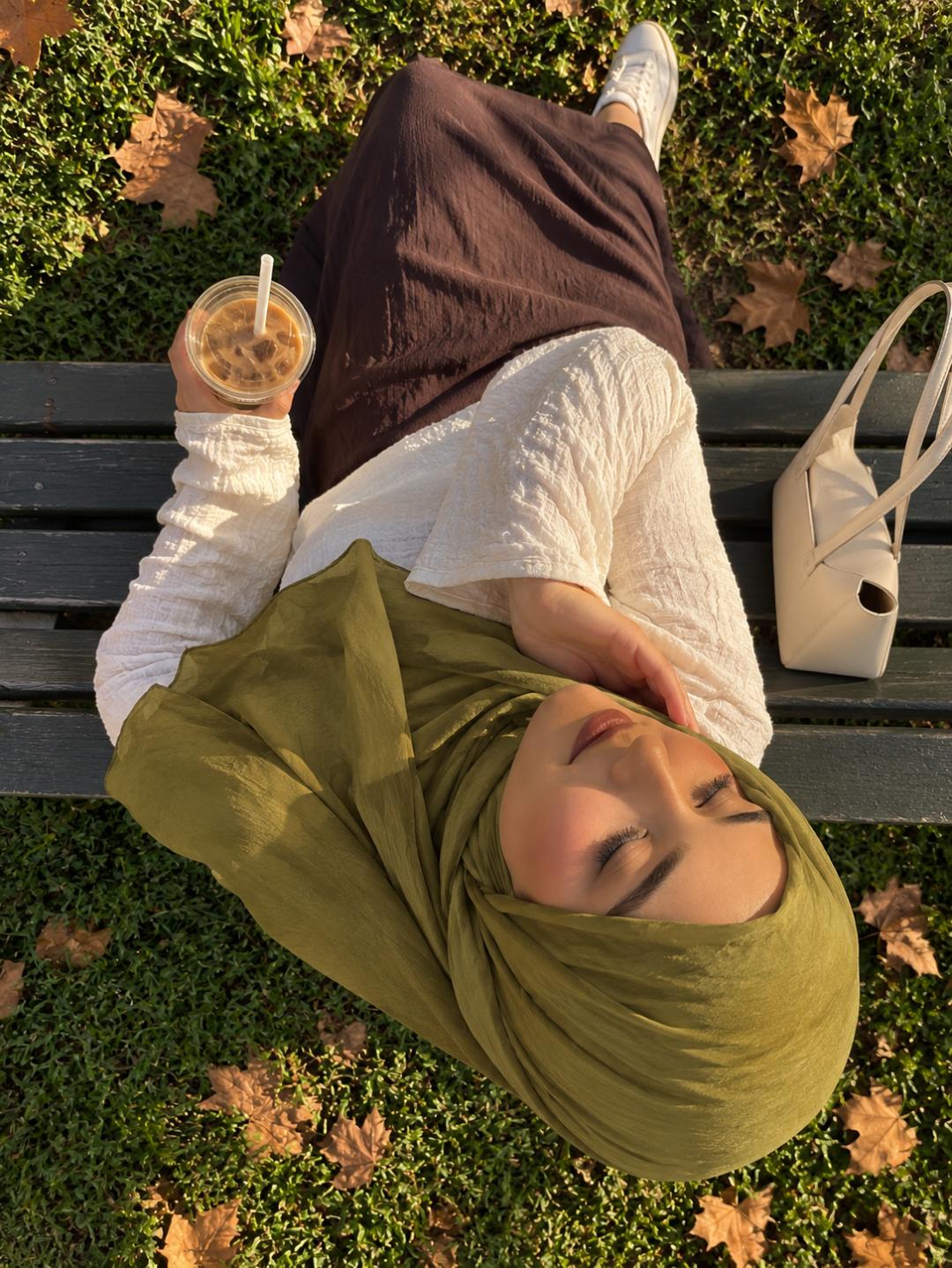 Châle vert olive porté en hijab avec une tenue écrue